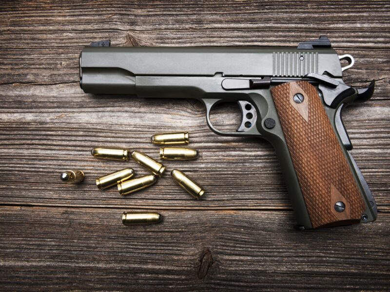 Group of Bullets and Gun on wood background